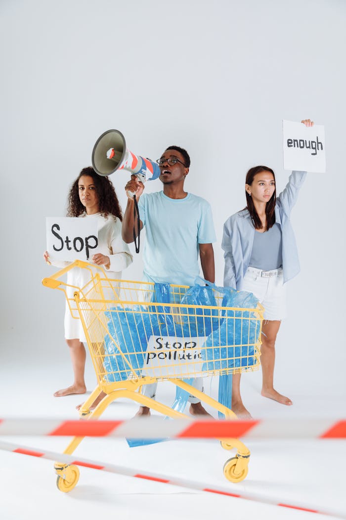 Diverse group of young adults protesting plastic pollution holding signs and a megaphone.